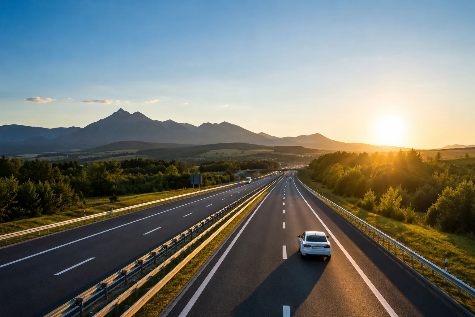 Osobné auto jazdiace po modernej slovenskej diaľnici pri západe slnka – ilustračná fotografia k téme diaľničná známka na Slovensku v roku 2026.